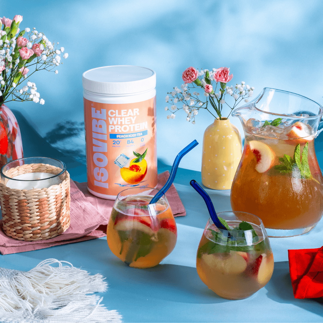 Peach Iced Tea on blue backdrop with jug of ISOVIBE and two glasses