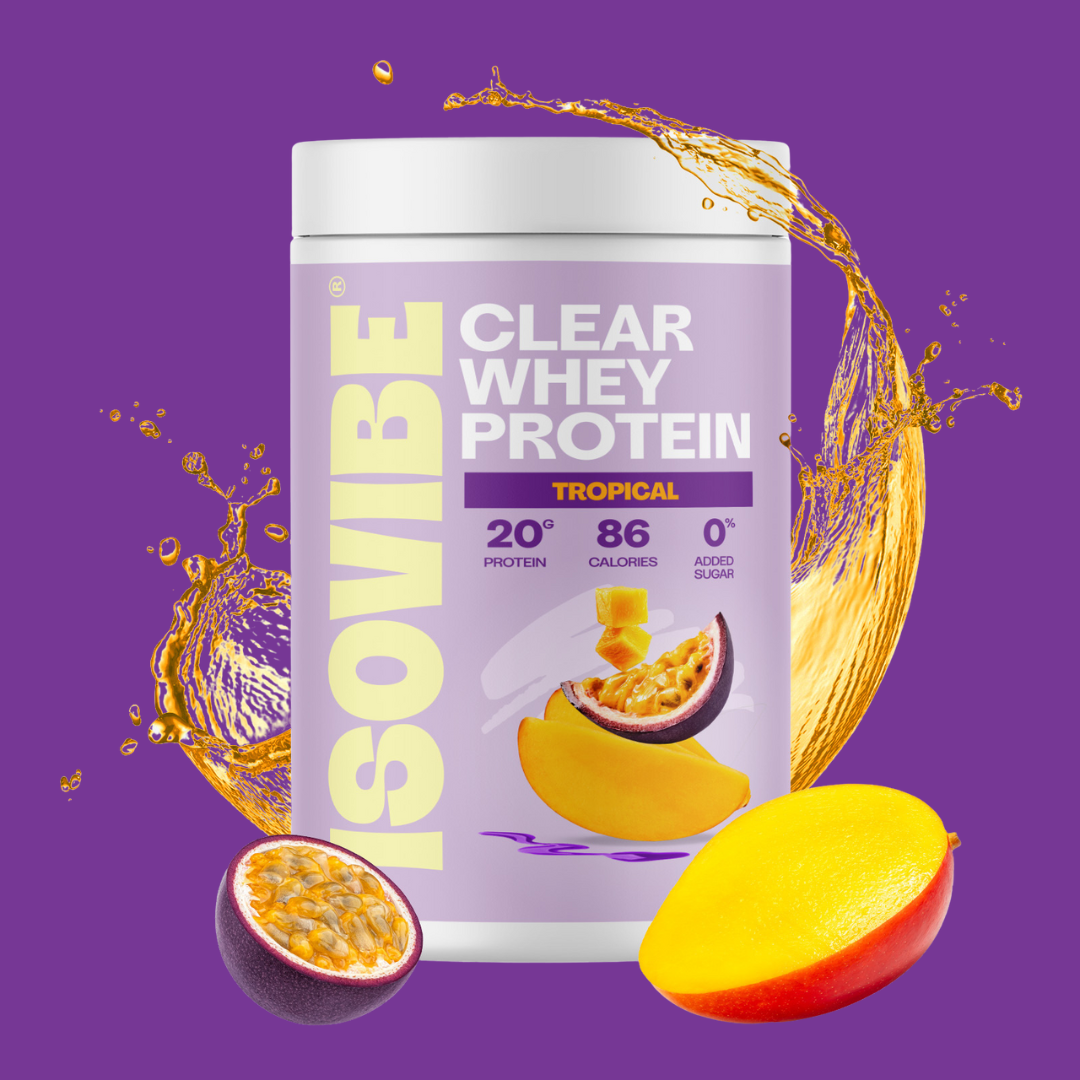 Tropical ISOVIBE tub with water droplets and mango and passionfruit in front on a purple background