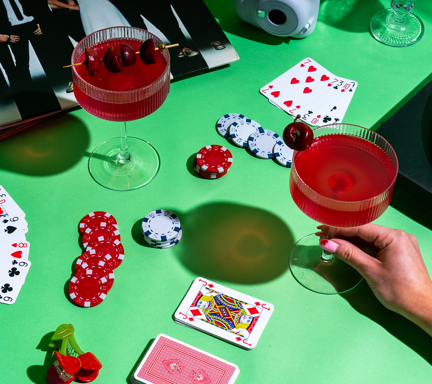 sour cherry protein mocktail on poker table alongside playing cards and poker chips